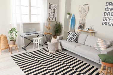 Sörf tahtası, sentezleyici ve kanepesi olan şık bir oturma odası.