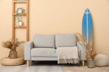 Sörf tahtası, raf ünitesi ve kanepesi olan modern şık bir oda.