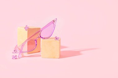 Pembe arka planda şık güneş gözlüklü podyumlar