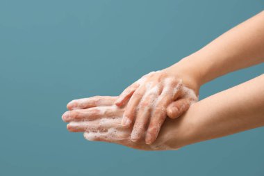 Mavi arka planda sabun köpüğünde eller