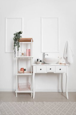 Lavabo lavabosu ve raf ünitesi olan bir masa.