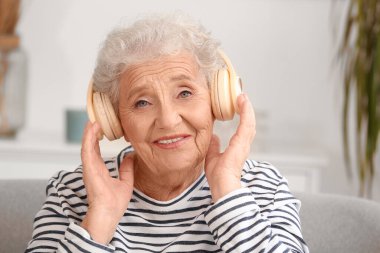 Evde kulaklıklı yaşlı kadın, yakın plan.
