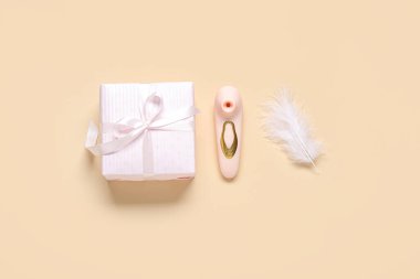 Vibratörlü kompozisyon, hediye kutusu ve bej arka planda tüy