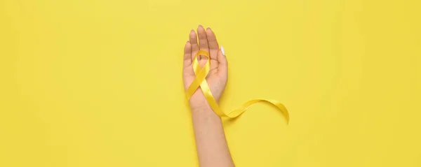 Hand Mit Goldenem Band Auf Gelbem Hintergrund Krebskonzept — Stockfoto