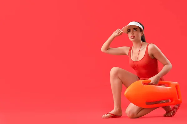 Vrouwelijke Badmeester Met Reddingsboei Rode Achtergrond — Stockfoto