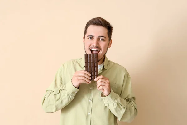 Joven Comiendo Sabroso Chocolate Sobre Fondo Beige — Foto de Stock