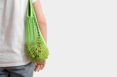 Taze üzümlü kadın ağ torbasında, arka planda.