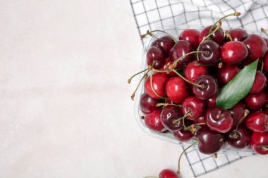 Beyaz arka planda taze kirazlı plastik kap, yakın plan.