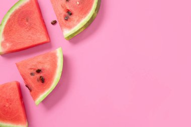 Pembe arka planda olgun karpuz parçaları olan kompozisyon, yakın plan.