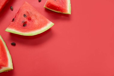 Kırmızı arkaplanda olgun karpuz parçaları, yakın plan.