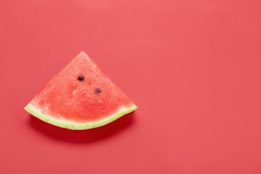 Kırmızı arkaplanda olgun bir karpuz parçası