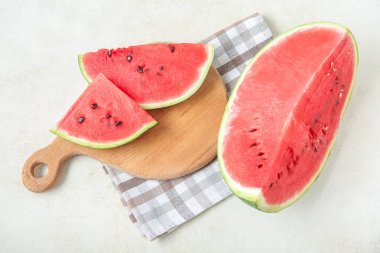Açık arkaplanda taze olgun karpuz parçaları olan tahta.