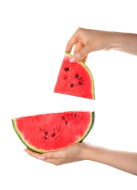 Beyaz arka planda olgun karpuz parçaları olan kadın eller.