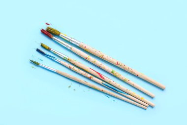 Sanatçı fırçaları mavi arka planda boya ile