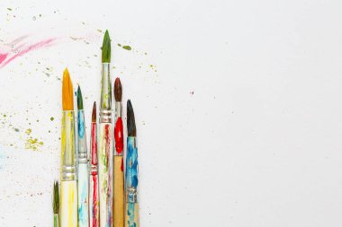 Beyaz arkaplanda sanatçının fırçaları ve boyaları