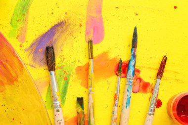Sanatçı fırçaları ve sarı arkaplan boyaları