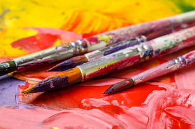 Renkli arka planda kirli boya fırçaları