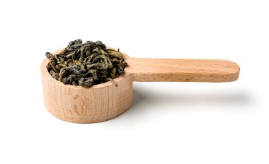 Beyaz arka planda kuru yeşil çay yapraklı ahşap kaşık.