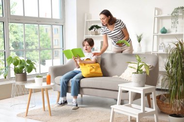 Anne, küçük oğluna ev ödevinde yardım ediyor.