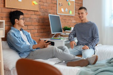 Yurt odasında erkek öğrenciler konuşuyor.