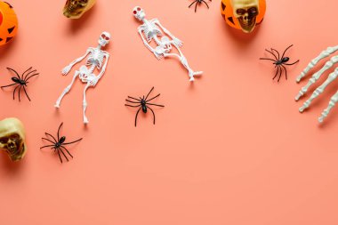 İskelet, el, kafatası, balkabağı ve örümcekli kompozisyon mercan arka planda Cadılar Bayramı kutlaması için