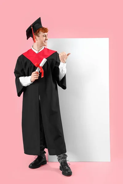 Mężczyzna Absolwent Student Dyplomem Wskazując Puste Plakat Różowym Tle — Zdjęcie stockowe