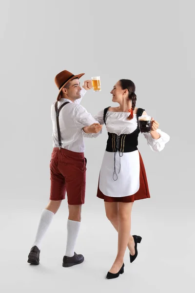 Νεαρό Ζευγάρι Παραδοσιακά Γερμανικά Ρούχα Μπύρα Χορεύουν Στο Φως Φόντο — Φωτογραφία Αρχείου