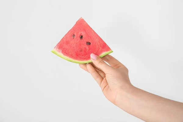 Female hand with fresh ripe watermelon on white background