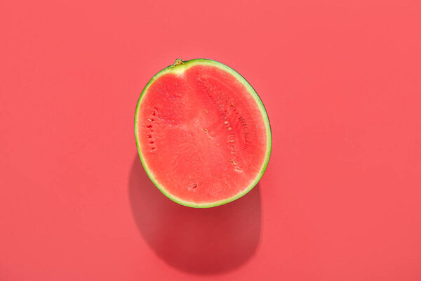 Half of ripe watermelon on red background