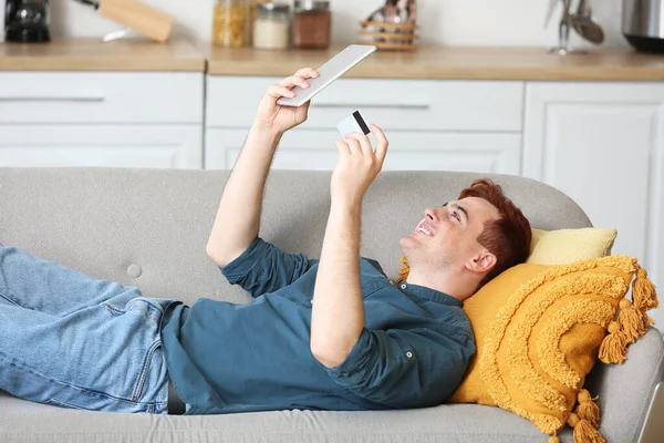 Handsome Young Man Credit Card Tablet Computer Lying Sofa While — Stock Photo, Image