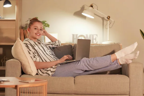 stock image Young woman working with laptop at home in evening