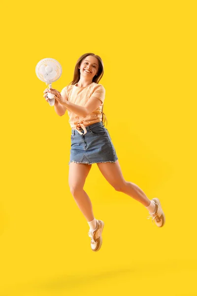 Young Woman Electric Fan Jumping Yellow Background — Stock Photo, Image