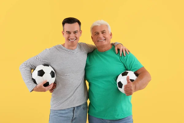 Young Man His Father Soccer Balls Hugging Yellow Background — Stock Photo, Image