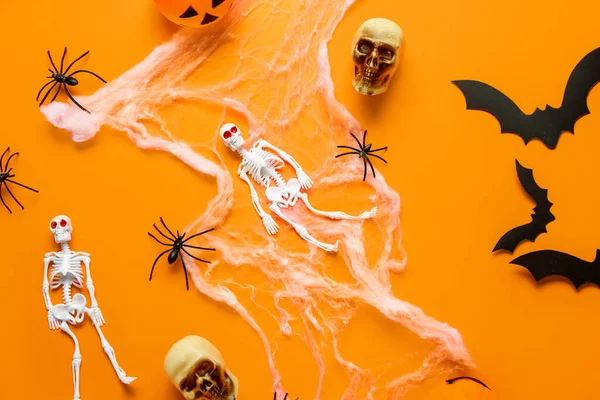 stock image Composition with skeletons, skulls, web, paper bats and spiders for Halloween celebration on orange background