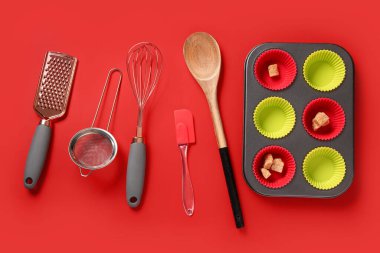 Baking forms and utensils on red background clipart