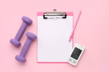 Pembe arka planda glukometresi ve dambılı boş bir pano. Diyabet kavramı