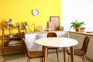 Yemek masası ve tezgahları olan şık bir mutfak.