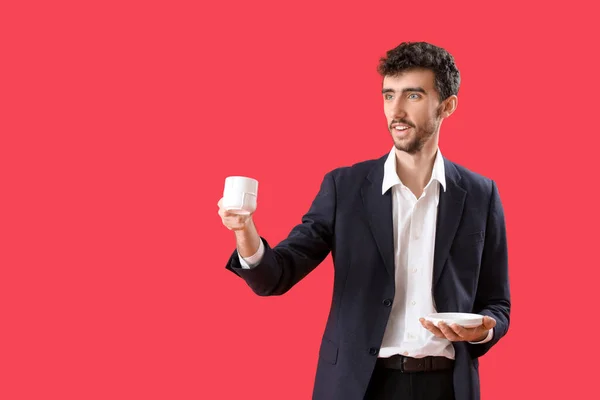 Młody Mężczyzna Garniturze Filiżanką Kawy Czerwonym Tle — Zdjęcie stockowe