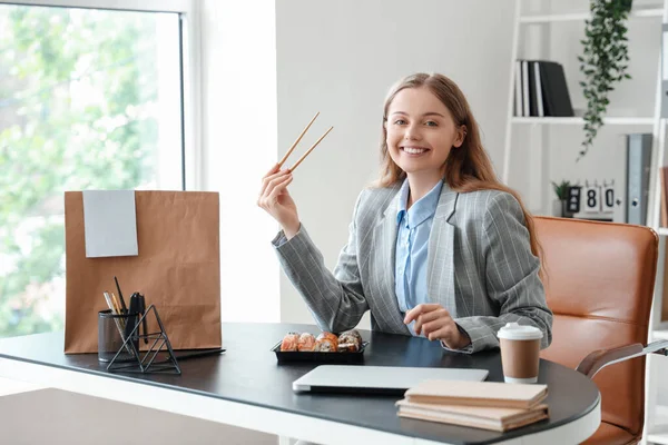 Šťastná Mladá Žena Jíst Sushi Kanceláři — Stock fotografie