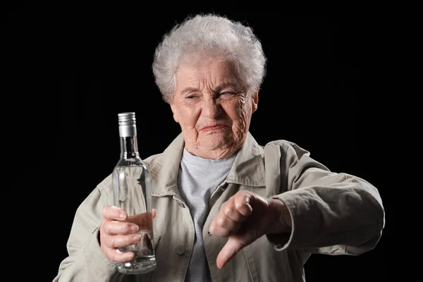 Senior Kvinna Med Flaska Vodka Visar Tummen Ner Svart Bakgrund — Stockfoto