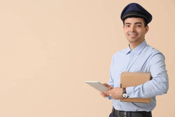 Young Postman Tablet Computer Parcel Beige Background — Stock Photo, Image