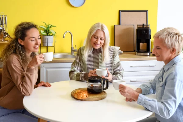 Mature women drinking coffee in kitchen