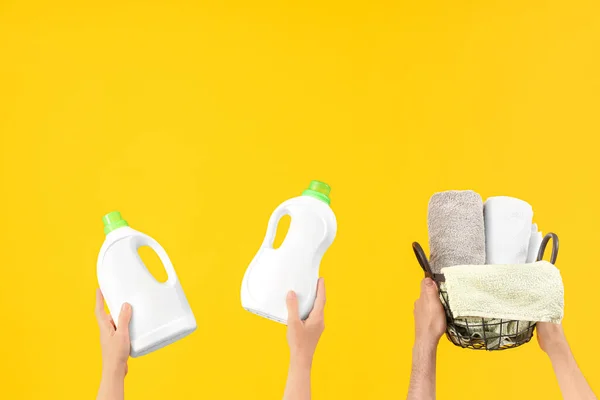 Ludzie Butelkami Detergentu Prania Czystymi Ręcznikami Żółtym Tle — Zdjęcie stockowe