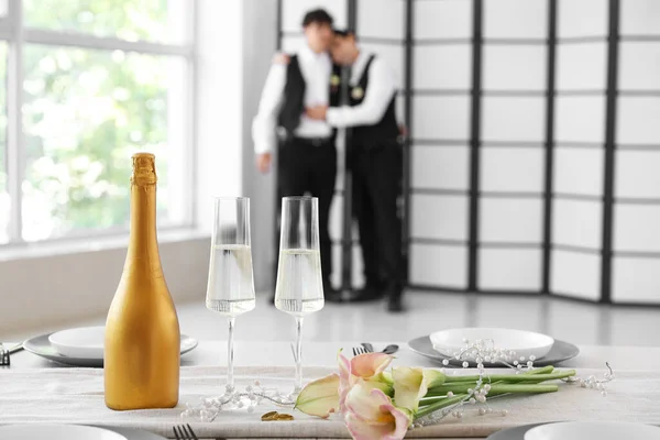 Champagne with flowers on table of married gay couple, closeup