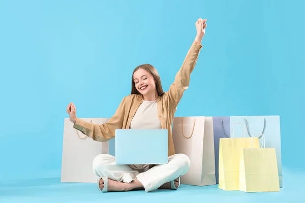 Mooie Jonge Vrouw Met Laptop Boodschappentassen Blauwe Achtergrond Online Winkelen — Stockfoto
