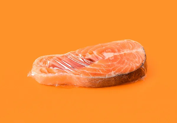 Fresh Salmon Steak Plastic Food Wrap Orange Background — Stock Photo, Image