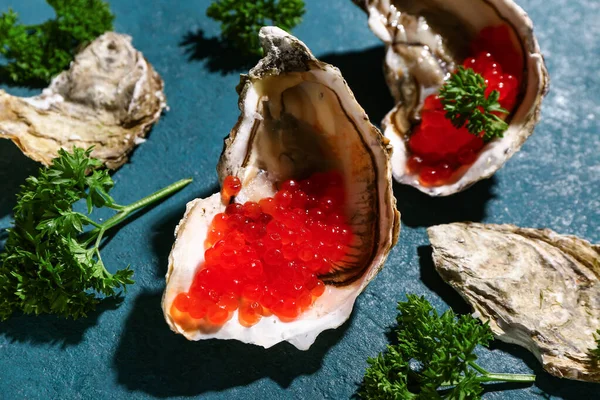 带有蓝色背景的红色鱼子酱的美味牡蛎 — 图库照片
