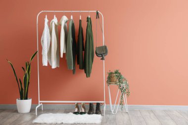 Renkli duvarın yanında kazak, çanta, ayakkabı ve çiçeklerle doldur