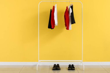 Sarı duvarın yanında şık bir okul üniforması var.