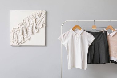 Gri duvarın yanında şık bir okul üniforması var.